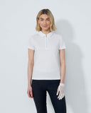 Woman wearing a white polo shirt and black pants on a plain background