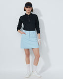 Person wearing a black top, light blue skirt, white shoes, and a visor on a white background