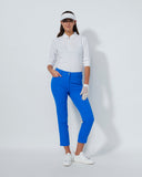 Woman in golf attire with blue pants, white shirt, and visor on a white background