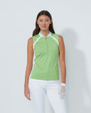 Woman wearing a green sleeveless top with white accents on a plain background