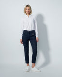 Woman wearing a white shirt and dark jeans on a plain background