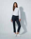 Woman wearing a white shirt and dark jeans on a gray background