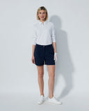 Person wearing a white shirt and navy shorts on a plain background