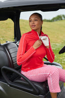 Girl wearing all read sitting in a golf cart.