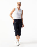 Woman wearing a white sleeveless top and black capri pants on a white background