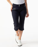 Person wearing navy blue capri pants with a white background