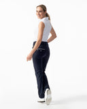 Woman wearing navy pants and a white top on a white background