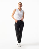 Woman wearing a white sleeveless top and black pants on a white background