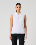 A woman modeling a white sleeveless polo shirt with a short zipper at the collar, paired with black pants and a white glove, against a light gray studio background.