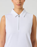 A woman wearing a white sleeveless polo golf shirt with a half-zip collar, shown from the chest up against a light gray studio background.