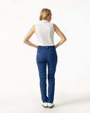 Woman wearing a white sleeveless top and blue pants on a white background