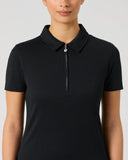 A woman wearing a black short-sleeve polo shirt with a half-zip collar, shown from the nose down against a light gray studio background.