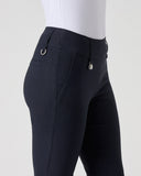 Close-up side view of a person wearing dark navy equestrian riding pants with a white top, shown against a light gray studio background.
