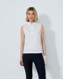 Woman wearing a white sleeveless top and black pants on a plain background