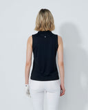 Woman wearing a black sleeveless top and white pants against a plain background