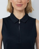 Woman wearing a black sleeveless dress with a collar on a white background