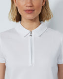 Person wearing a white polo shirt with a zipper on a plain background