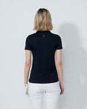 Person wearing a black polo shirt and white pants against a plain background