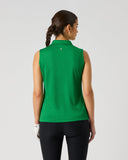 A woman viewed from the back wearing a bright green sleeveless collared golf shirt and black pants, standing against a light gray studio background.