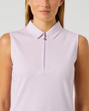 A woman wearing a sleeveless light lavender polo shirt with a half-zip collar, shown from the chest up against a plain light gray studio background.