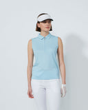 Woman wearing a light blue sleeveless polo shirt, white pants, and a visor on a plain background