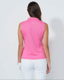 Woman wearing a pink sleeveless top and white pants on a light gray background