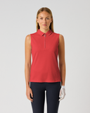 A woman modeling a sleeveless red polo-style golf shirt with a short front zipper, paired with dark pants and a white glove, against a plain light gray studio background.