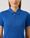 Person wearing a blue polo shirt with a zipper on a light gray background