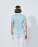 Person wearing a light blue polo shirt and white pants on a plain background