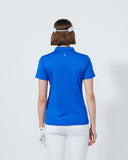 Person wearing a blue polo shirt and white pants on a light gray background