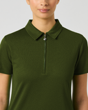 A woman wearing a dark olive green short-sleeve polo shirt with a half-zip collar, shown from the nose down against a light gray studio background.