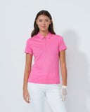 Person wearing a pink polo shirt and white pants on a plain background
