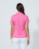 Person wearing a pink polo shirt and white pants on a plain background