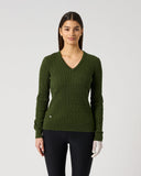 A woman modeling a dark olive green ribbed knit V-neck sweater with long sleeves, paired with black leggings, against a light gray studio background.
