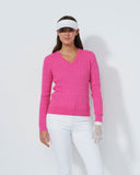 Woman wearing a pink sweater and white pants on a white background