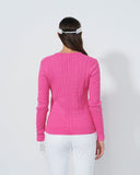 Person wearing a pink sweater and white pants on a plain background