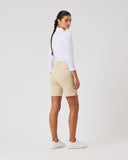 Person wearing a white long-sleeve shirt and beige shorts on a light gray background