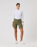 Woman wearing a white shirt and green shorts on a plain background