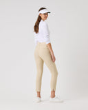 Woman wearing a white shirt, beige pants, and a visor on a white background