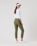 Woman wearing a white shirt, green pants, and a visor on a white background