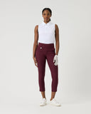 Woman wearing a white polo shirt, maroon pants, and white shoes on a white background