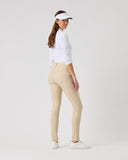 Woman wearing a white shirt, beige pants, and a visor on a light gray background