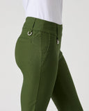 A close-up side view of a person wearing olive green riding breeches with a white top, shown against a plain light gray studio background.