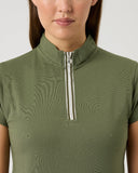 Person wearing a green short-sleeve top with a zipper detail on a light gray background