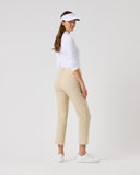 Woman wearing a white shirt, beige pants, and a visor on a light gray background