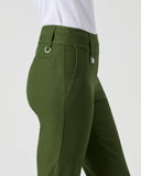 A side profile view of a person wearing olive green tailored trousers and a white top, shown against a plain light gray studio background.