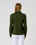 A woman viewed from the back wearing an olive green long-sleeve polo shirt and white pants, standing against a plain light gray studio background.