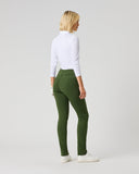 A woman with blonde hair is shown from the back wearing olive green slim-fit pants, a white long-sleeve mock neck top, and white sneakers, standing against a light gray studio background.