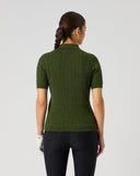 A woman viewed from behind wearing a dark olive green short-sleeve ribbed knit polo shirt and black leggings against a light gray studio background.