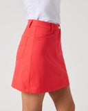 A model wearing a bright red A-line mini skirt with a white top, shown from the waist down against a light gray studio background.